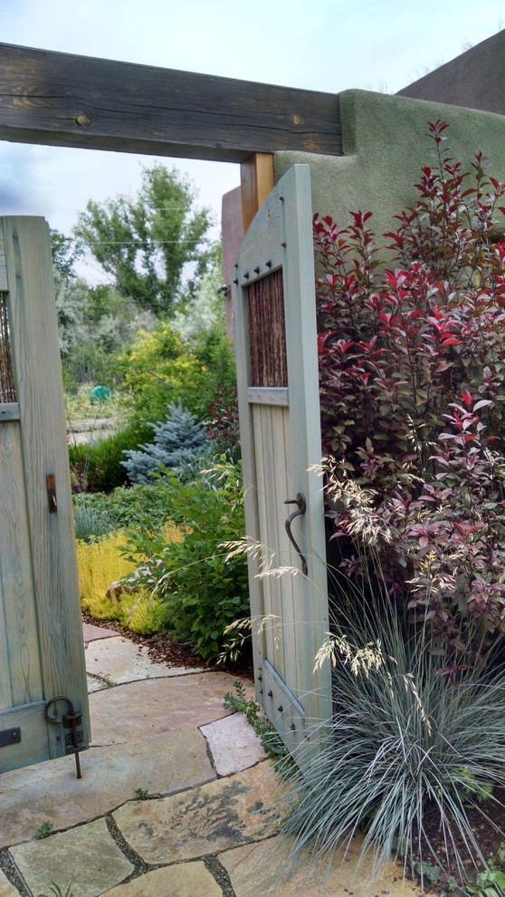 Foto di un giardino xeriscape stile americano esposto in pieno sole davanti casa in estate con un ingresso o sentiero e pavimentazioni in pietra naturale