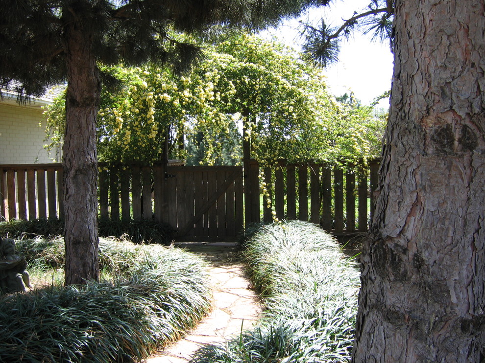 На фото: тенистый участок и сад на боковом дворе в классическом стиле с