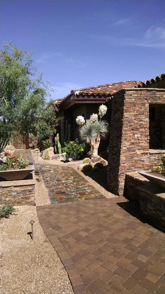Inspiration för en mellanstor amerikansk bakgård i full sol som tål torka, med en trädgårdsgång och naturstensplattor