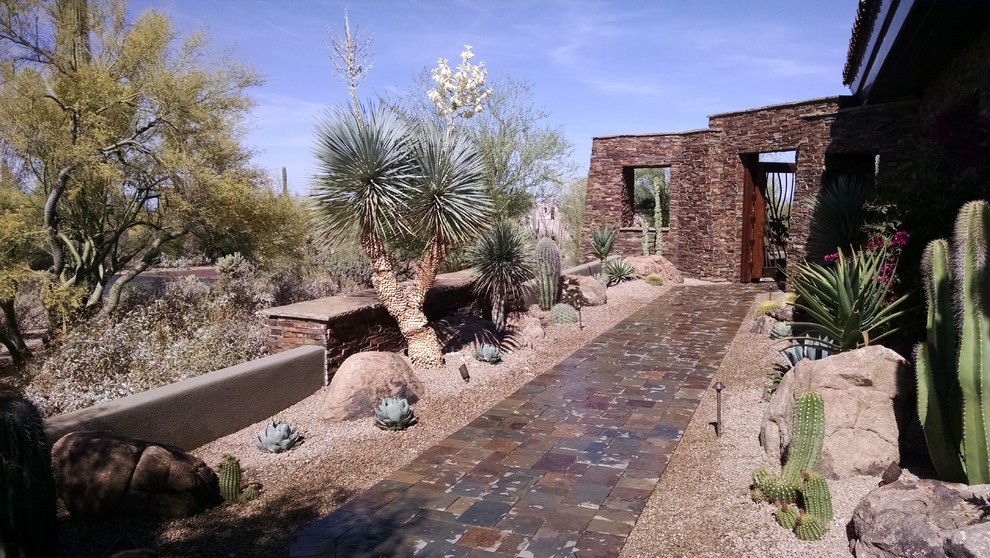 Mittelgroßer Mediterraner Gartenweg hinter dem Haus mit direkter Sonneneinstrahlung und Natursteinplatten in Phoenix