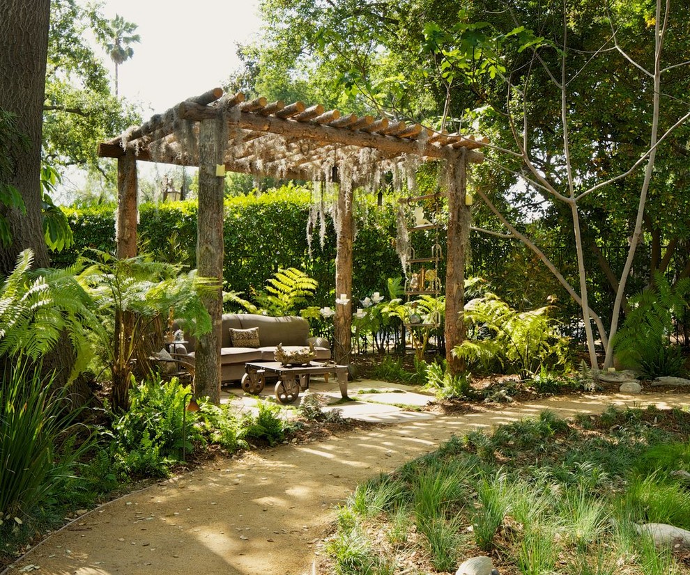 Modelo de jardín rústico de tamaño medio en patio trasero con exposición reducida al sol y pérgola