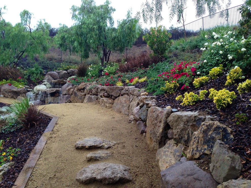 This is an example of a medium sized back xeriscape full sun garden in Los Angeles with mulch.
