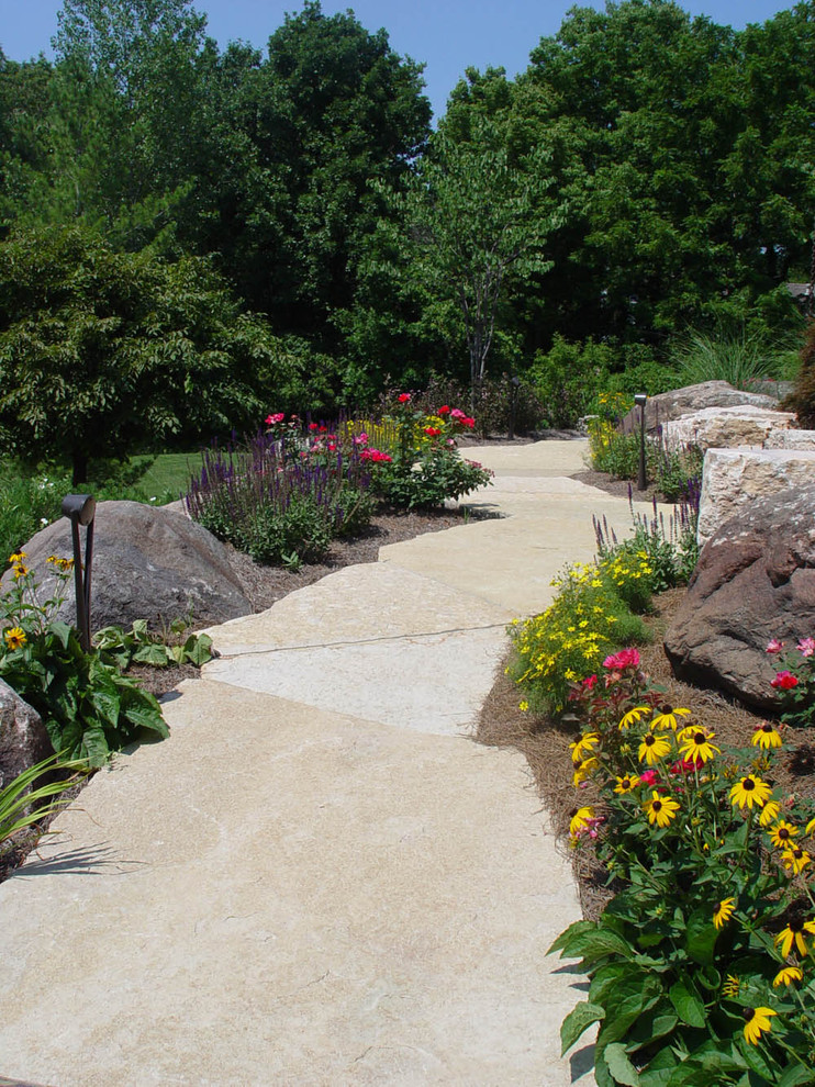 Foto di un grande giardino chic esposto in pieno sole dietro casa con un ingresso o sentiero e pavimentazioni in pietra naturale