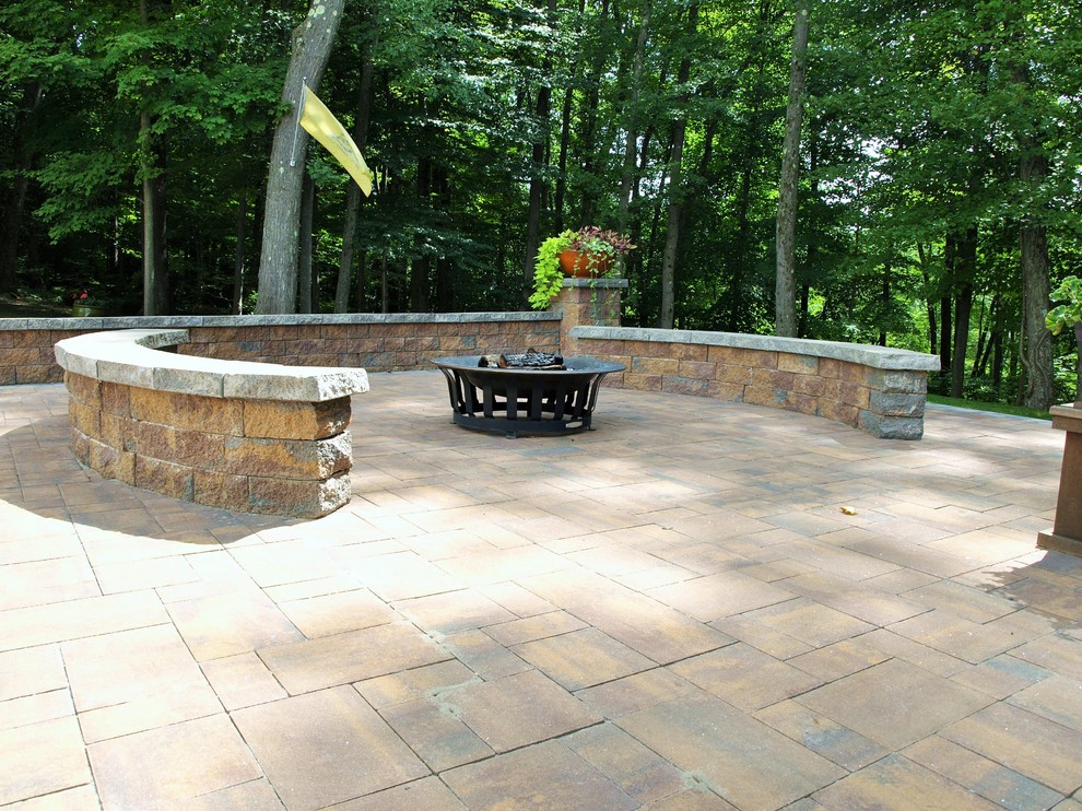 Photo of a large traditional back patio in Other with a fire feature and natural stone paving.