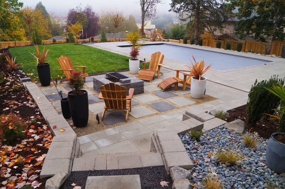 Cette image montre un grand jardin arrière minimaliste avec des pavés en béton.