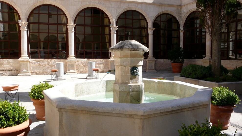 Idee per un grande giardino mediterraneo esposto a mezz'ombra dietro casa con fontane e pavimentazioni in pietra naturale