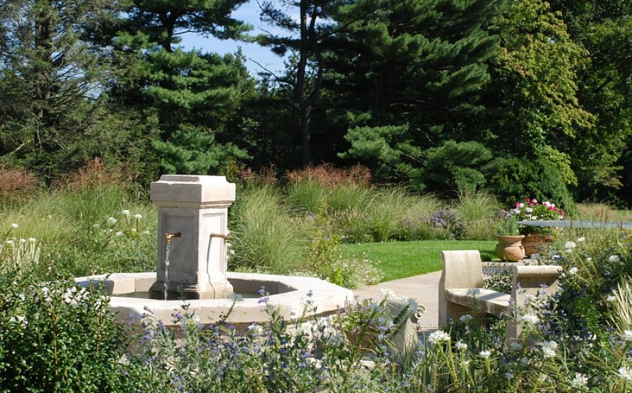 Photo of a large mediterranean partial sun backyard stone water fountain landscape in New York.