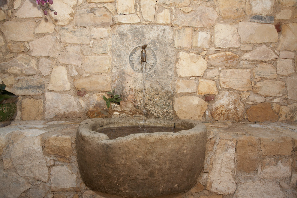 Ejemplo de jardín mediterráneo grande en patio trasero con fuente, exposición parcial al sol y adoquines de piedra natural