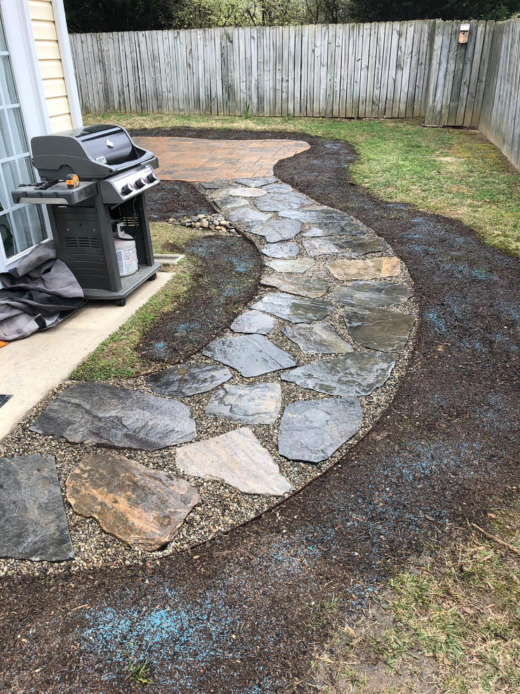 Medium sized classic back full sun garden for summer in Charlotte with natural stone paving.