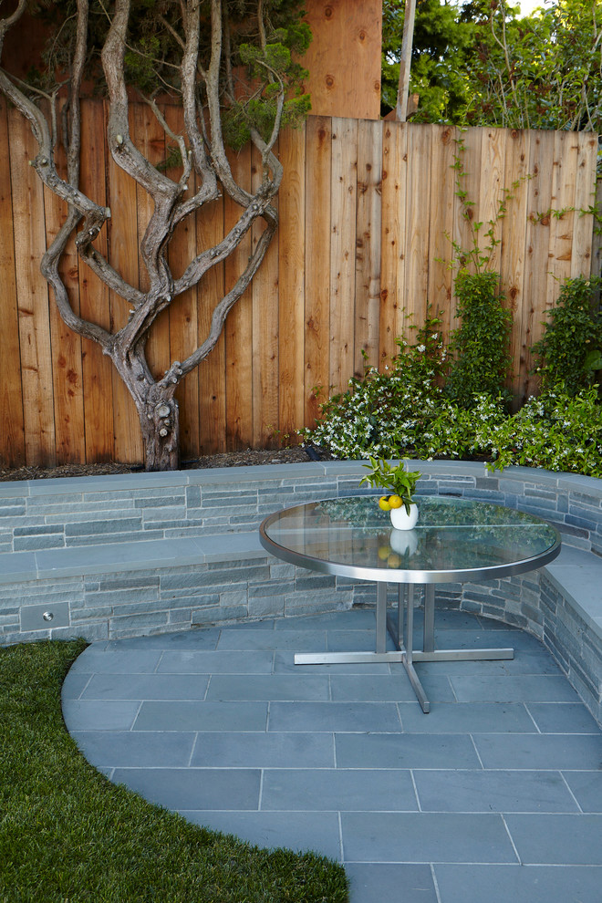 Пример оригинального дизайна: маленький участок и сад на заднем дворе в современном стиле с подпорной стенкой и покрытием из каменной брусчатки для на участке и в саду