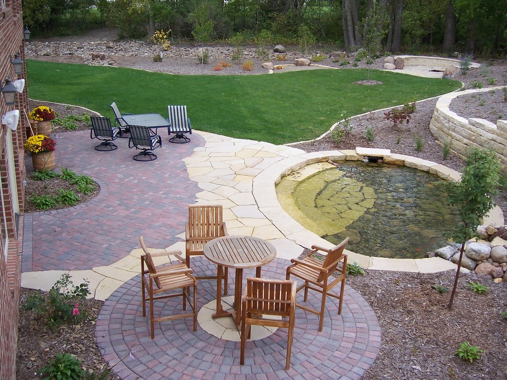 Idee per un grande laghetto da giardino classico dietro casa con pavimentazioni in mattoni