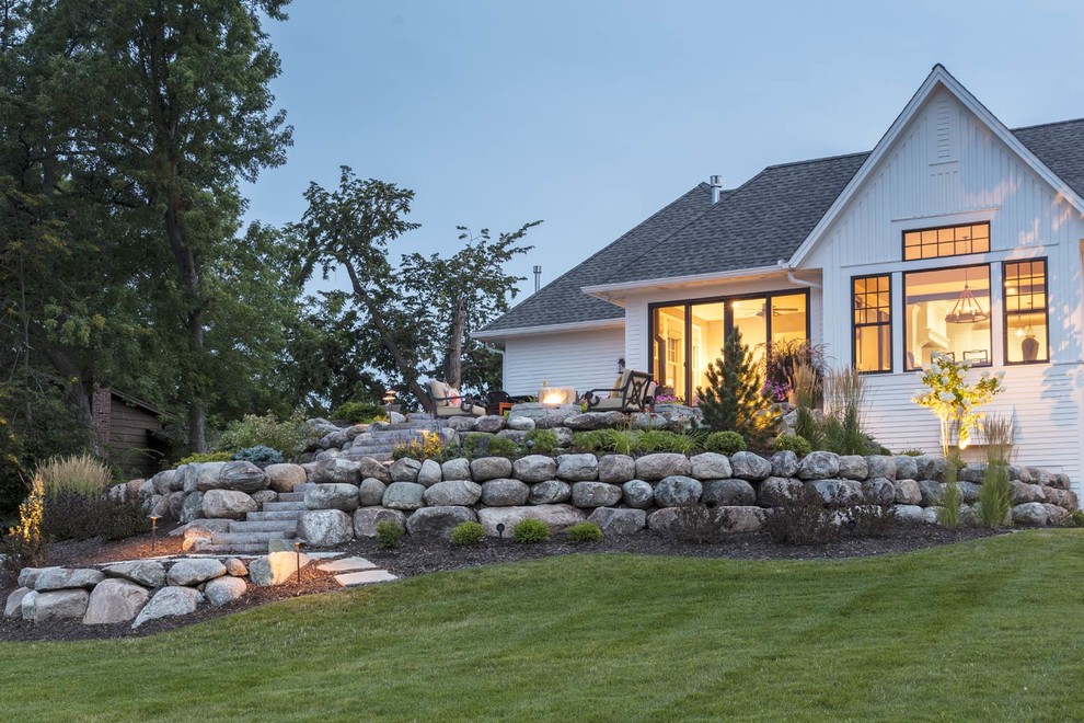 Идея дизайна: большой участок и сад на заднем дворе в классическом стиле с подпорной стенкой и покрытием из каменной брусчатки