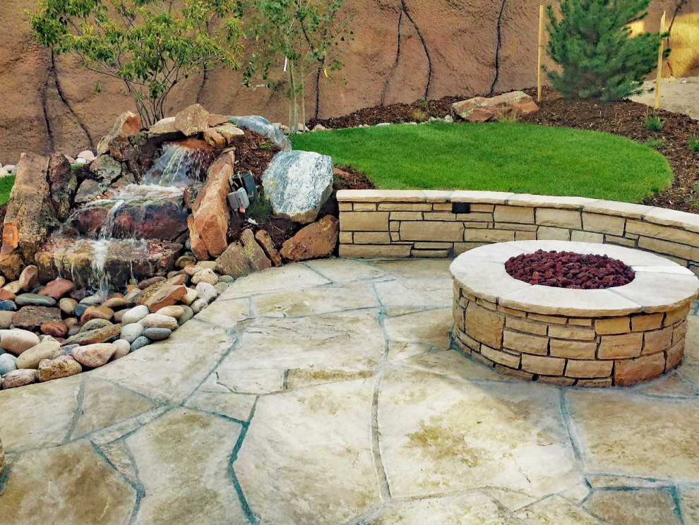 Cette image montre un petit jardin arrière design avec une cascade et des pavés en pierre naturelle.