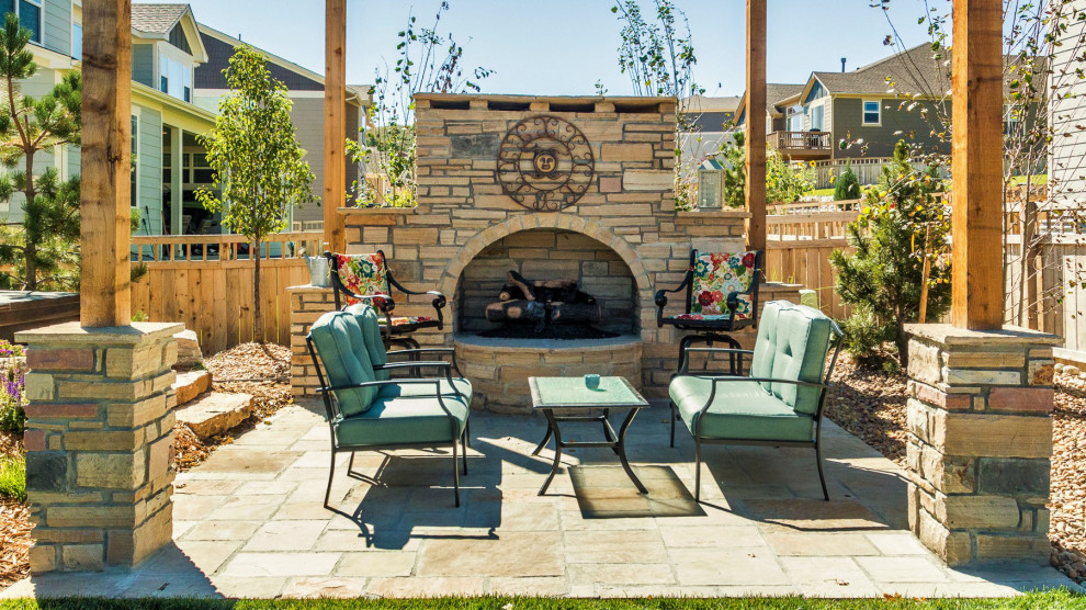 Medium sized contemporary back patio in Denver with a fireplace and natural stone paving.