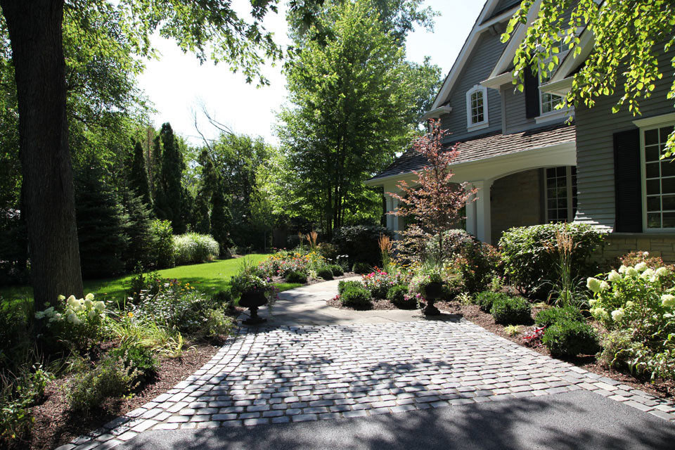 Inspiration for a large traditional partial sun front yard stone landscaping in Chicago.