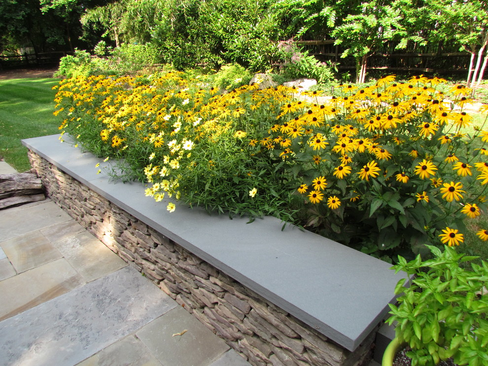 Inspiration for a mid-sized eclectic backyard concrete paver retaining wall landscape in Philadelphia.