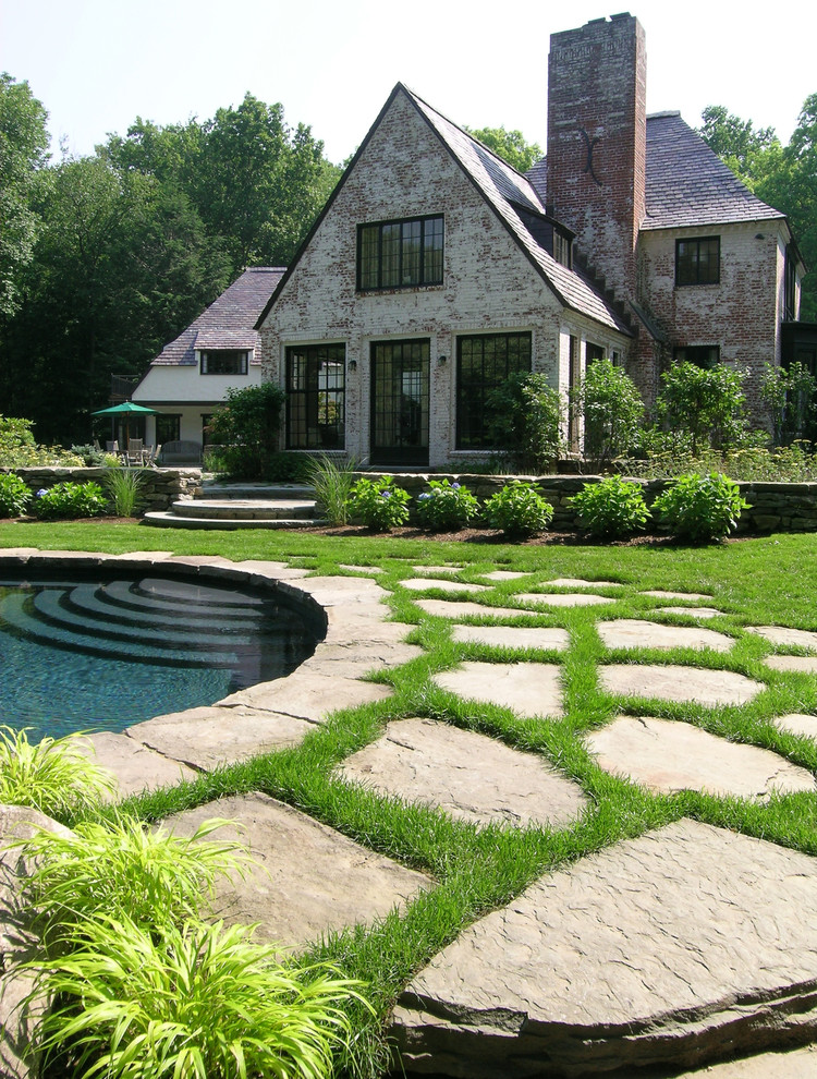 Foto di un grande giardino tradizionale esposto a mezz'ombra dietro casa con pavimentazioni in pietra naturale