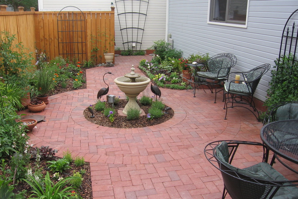 Small classic back patio in Denver with brick paving.