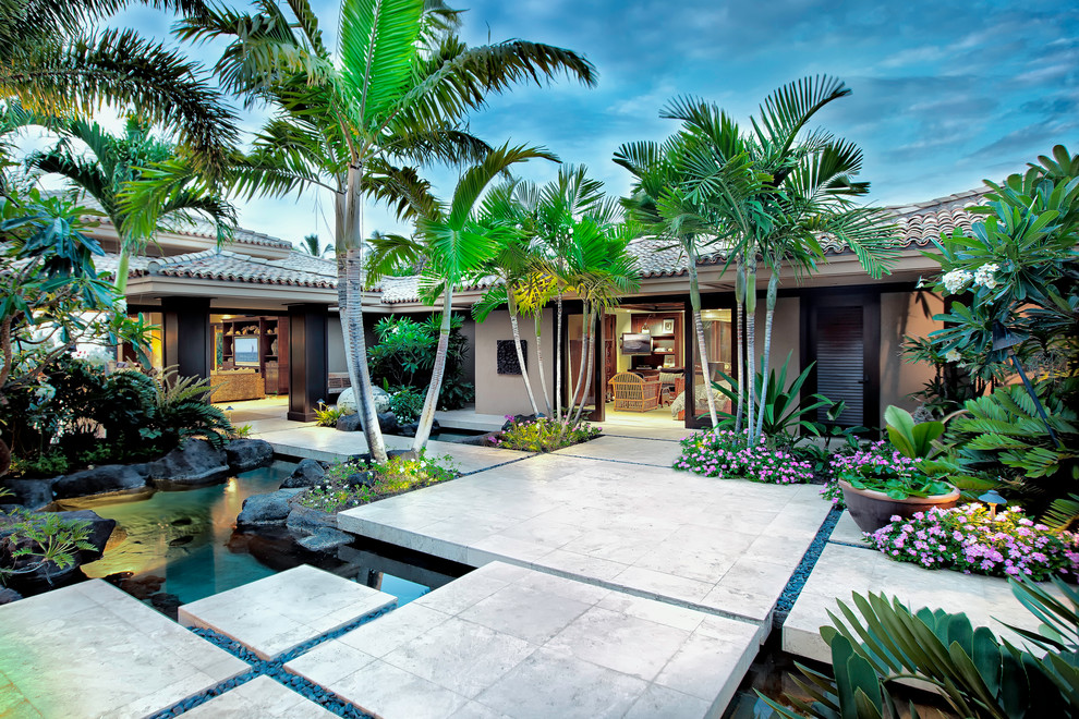 Foto de jardín tropical de tamaño medio en patio delantero con estanque, exposición reducida al sol y adoquines de hormigón