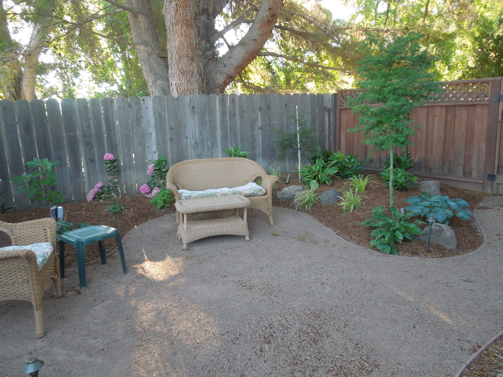 Photo of a mid-sized rustic drought-tolerant and shade side yard gravel landscaping in San Francisco for summer.
