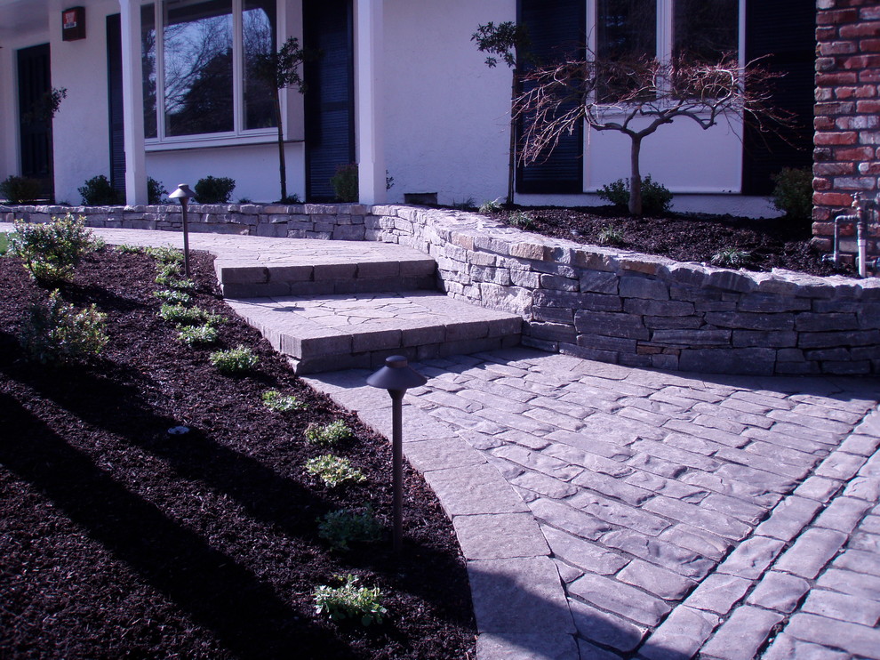 This is an example of a medium sized classic front driveway partial sun garden in San Francisco with concrete paving.