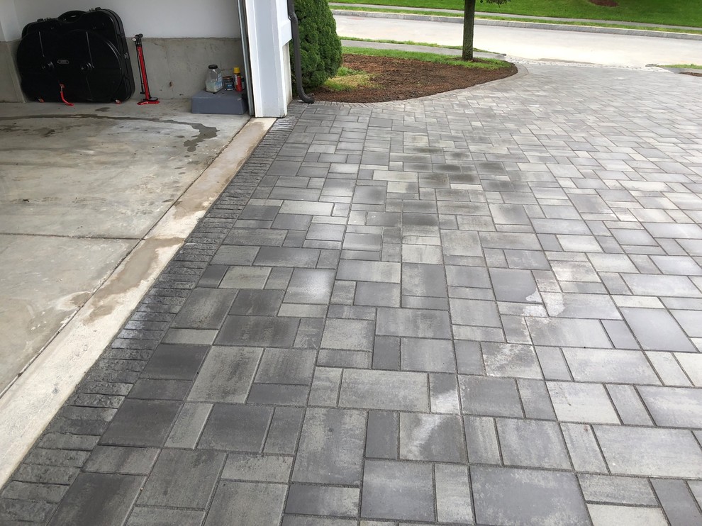 Inspiration for a large modern front driveway garden in Boston with concrete paving.