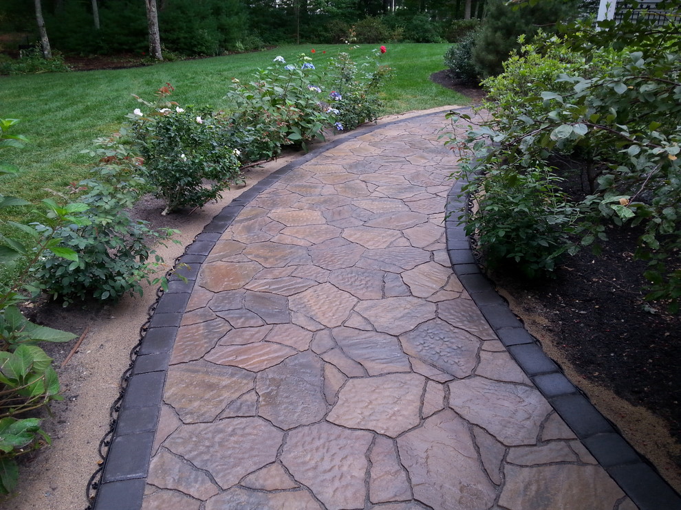Design ideas for a large traditional front driveway partial sun garden in Portland Maine with concrete paving.