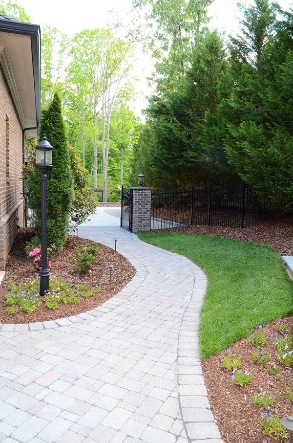 Immagine di un grande giardino classico esposto a mezz'ombra dietro casa con un ingresso o sentiero e pavimentazioni in cemento