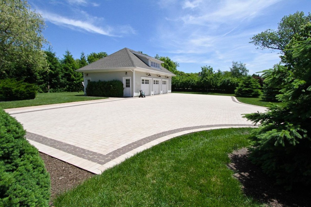 This is an example of a large beach style front driveway partial sun garden in New York with concrete paving.