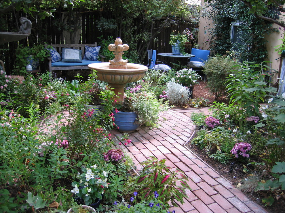Cette image montre un petit jardin sur cour traditionnel l'été avec un point d'eau, une exposition partiellement ombragée et des pavés en brique.