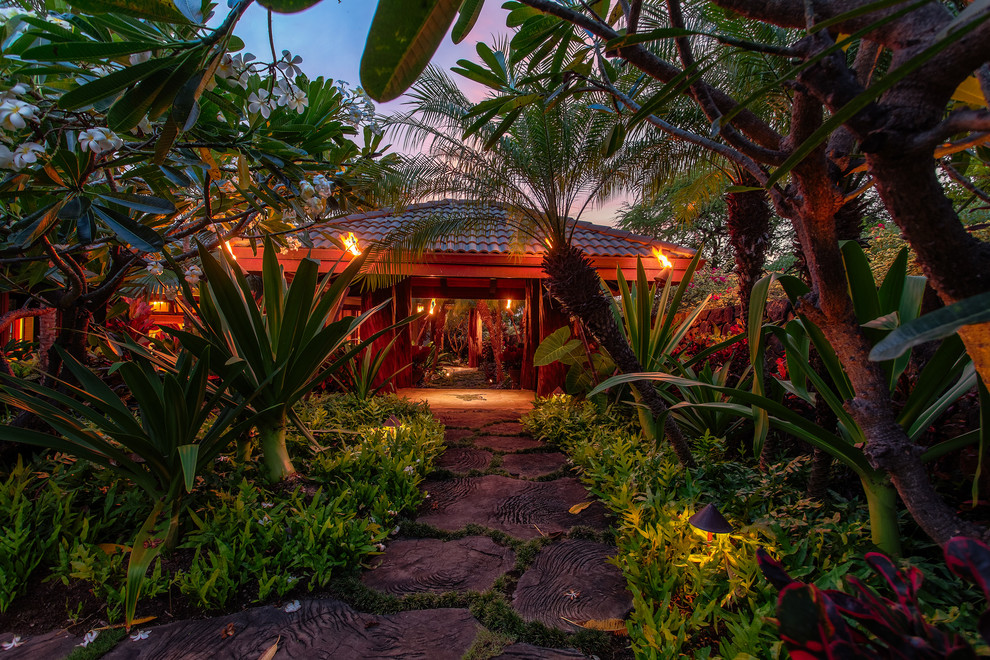 Esempio di un ampio giardino tropicale esposto a mezz'ombra davanti casa in estate con un ingresso o sentiero e pavimentazioni in pietra naturale