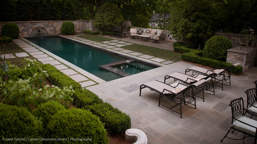 Modelo de jardín clásico grande en patio trasero con fuente y adoquines de piedra natural