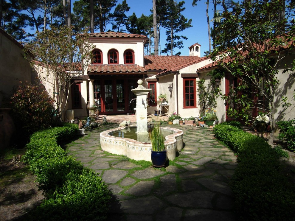 Foto di un giardino formale mediterraneo esposto a mezz'ombra di medie dimensioni e davanti casa in estate con fontane e pavimentazioni in pietra naturale