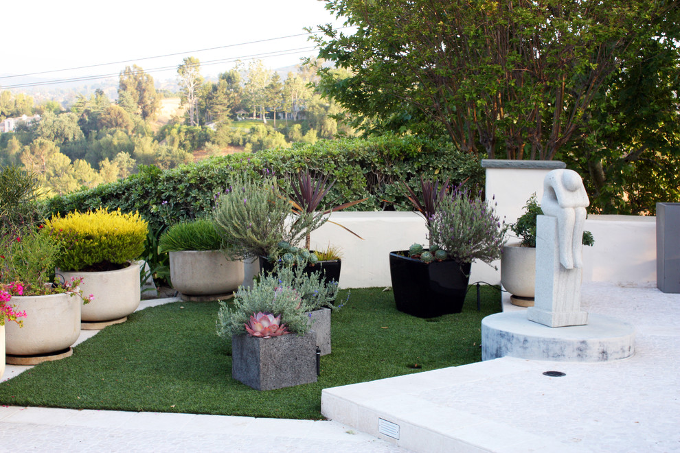 This is an example of a large contemporary back full sun garden in Los Angeles with a water feature and natural stone paving.