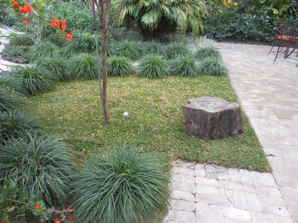 Foto de jardín tropical grande en patio trasero con huerto, exposición parcial al sol y adoquines de ladrillo