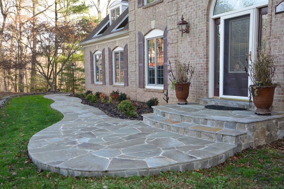 This is an example of a mid-sized traditional partial sun front yard stone landscaping in DC Metro for summer.