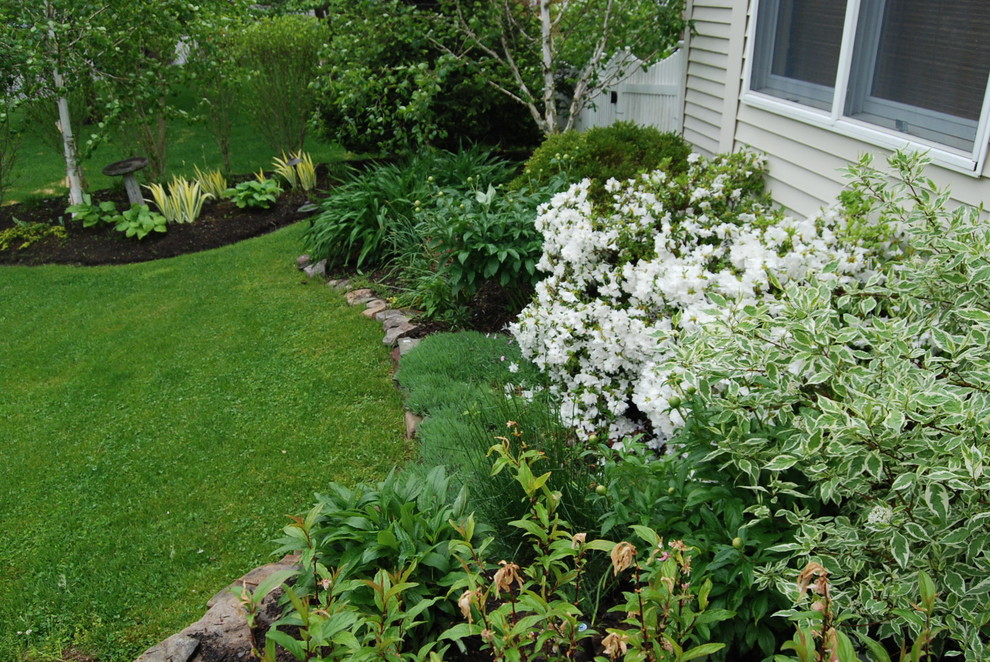 Photo of a mid-sized transitional full sun front yard stone landscaping in New York for summer.