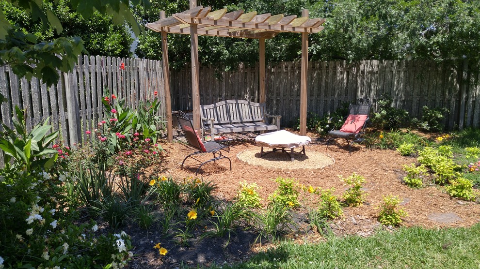 Ejemplo de jardín rural de tamaño medio en verano en patio trasero con jardín francés, brasero, exposición total al sol y mantillo
