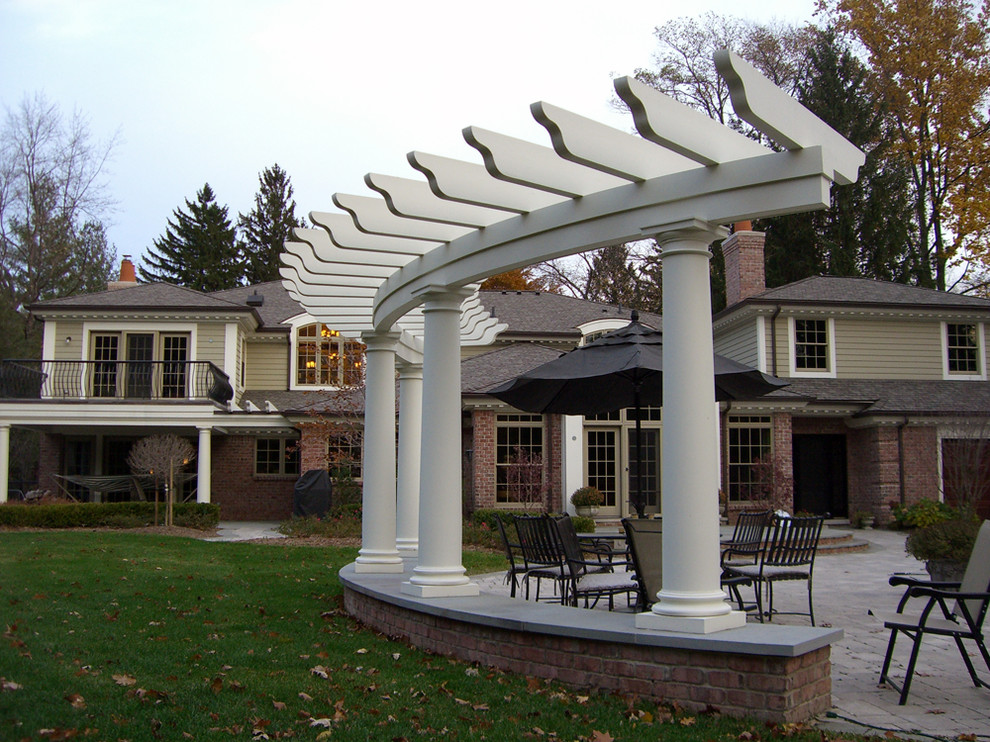 Inspiration for a large classic back formal partial sun pergola in Detroit with natural stone paving.