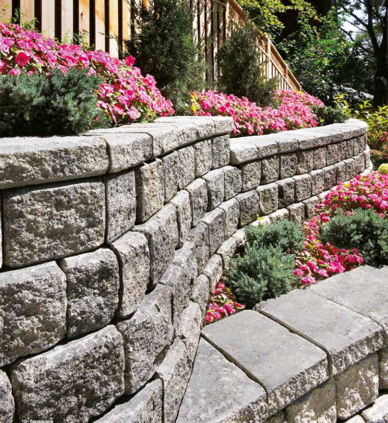 Cette photo montre un grand jardin chic l'été avec une exposition ensoleillée, un mur de soutènement et des pavés en pierre naturelle.