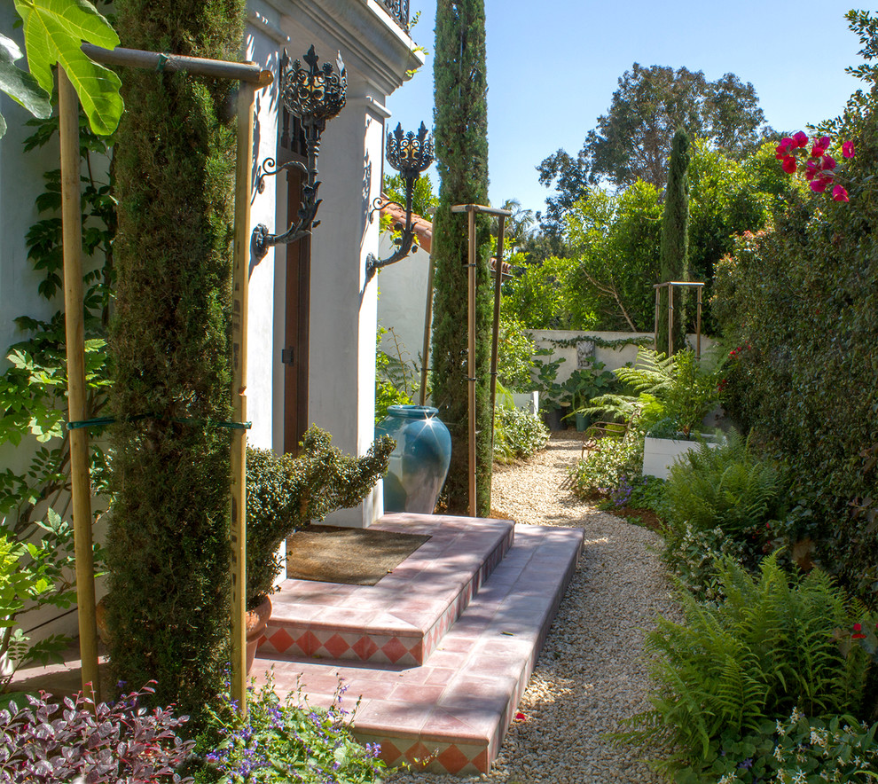 Diseño de camino de jardín mediterráneo pequeño en verano en patio delantero con jardín francés, exposición parcial al sol y gravilla