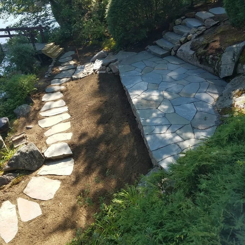 Inspiration pour un jardin arrière traditionnel de taille moyenne avec des pavés en pierre naturelle.