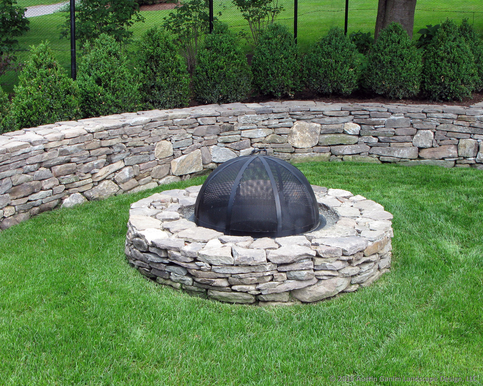 Design ideas for a traditional full sun side yard stone landscaping in New York with a fire pit for summer.