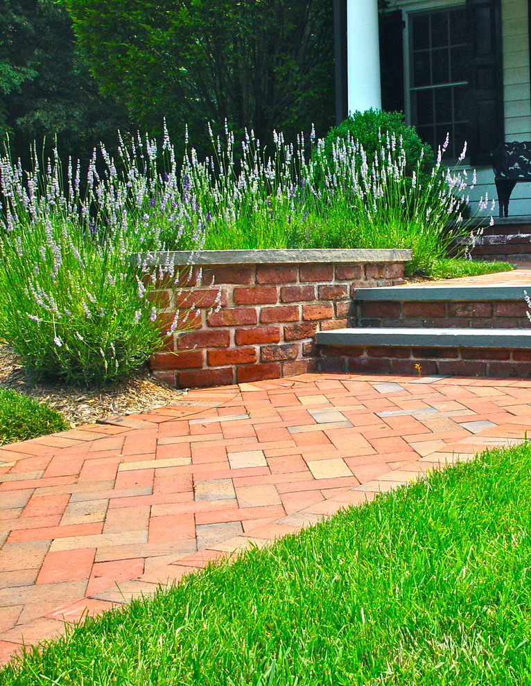 Inspiration for a mid-sized traditional front yard brick landscaping in New York.
