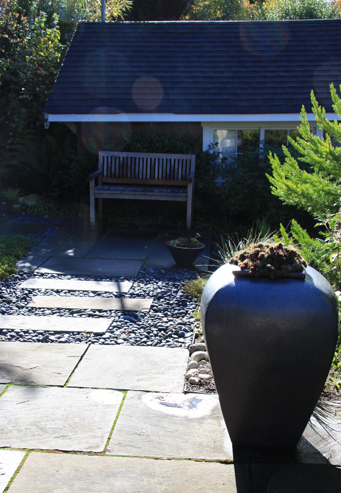 Réalisation d'un petit jardin arrière design avec une exposition partiellement ombragée et des pavés en pierre naturelle.