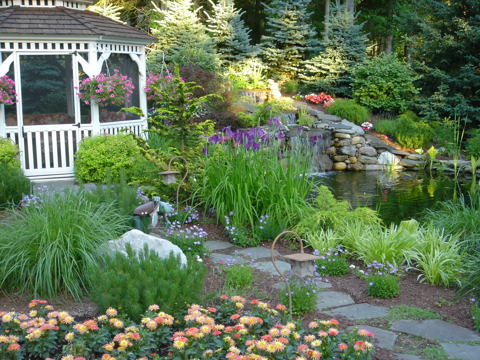 Inspiration for a large shade backyard stone water fountain landscape in New York for summer.