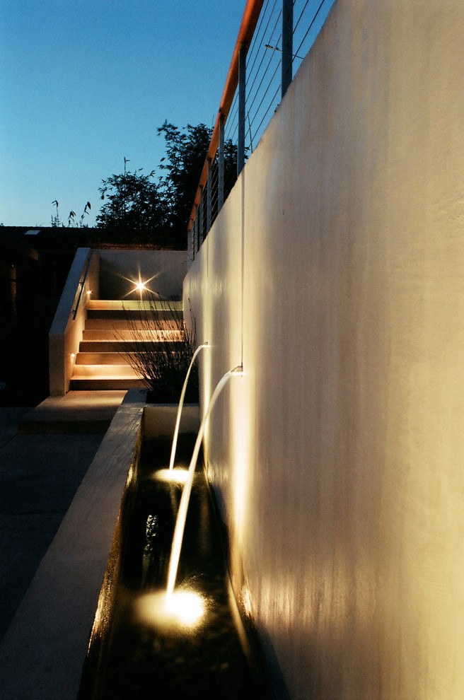 Idee per un giardino minimalista di medie dimensioni e dietro casa con fontane e pavimentazioni in cemento