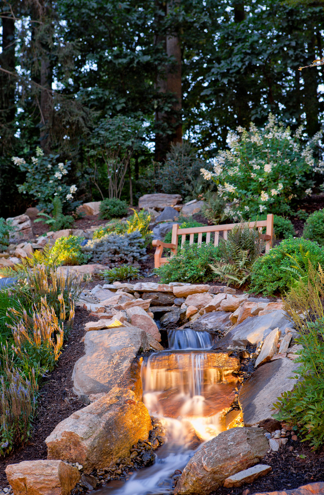 Design ideas for a sloped garden in Baltimore with a water feature.