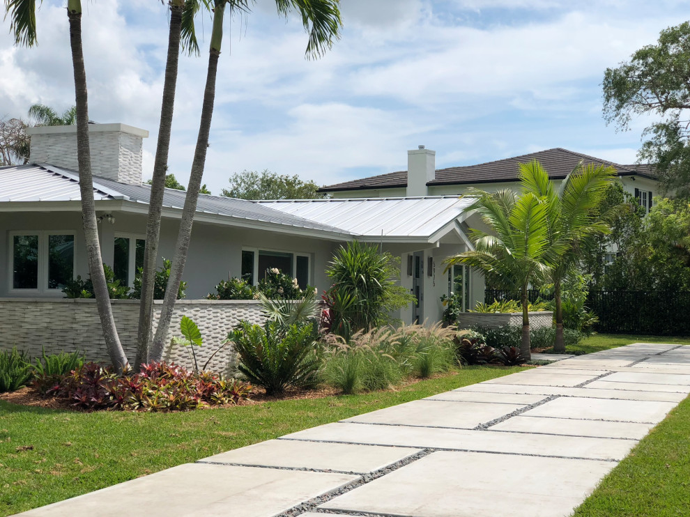 Großer Moderner Vorgarten mit Auffahrt, direkter Sonneneinstrahlung und Betonboden in Miami