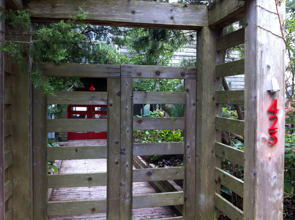 Réalisation d'un jardin avant bohème avec une terrasse en bois.
